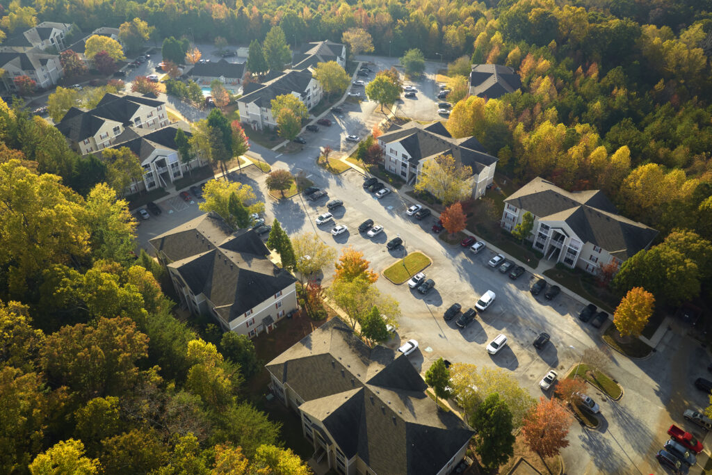 View from above of apartment residential condos between yellow fall trees in suburban area in South Carolina. American homes as example of real estate development in US suburbs.